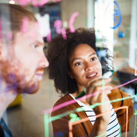 Consulting team discussing project plans at the whiteboard.